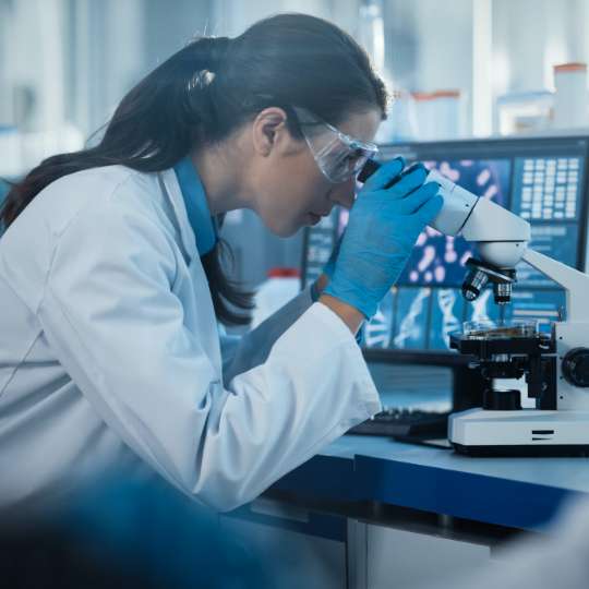 woman looking through microscope